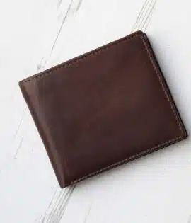 brown leather wallet with coin zipped pocket on wood background