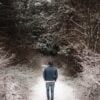 man wearing a wombat hat walking in the snow