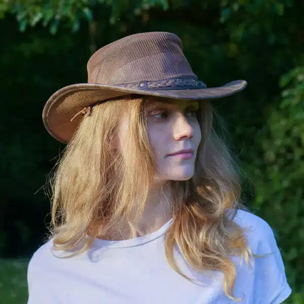 woman wearing a wombat the wilds air brown leather hat with mesh sides