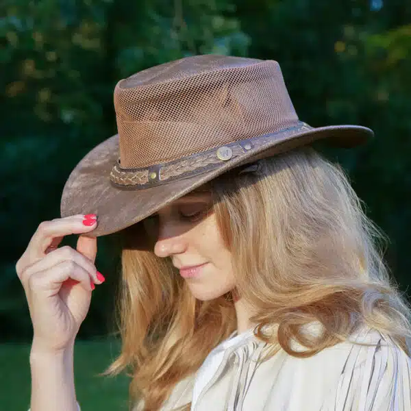 woman wearing a wombat the wilds air brown leather hat with mesh sides