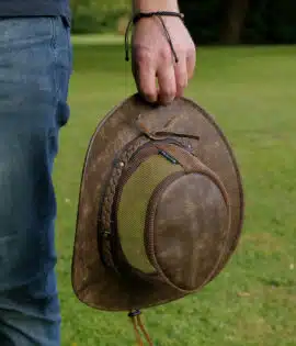 man holding a wombat the wilds air brown leather hat with mesh sides