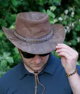 man wearing a wombat the wilds air brown leather hat with mesh sides