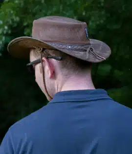 man wearing a wombat the wilds air brown leather hat with mesh sides