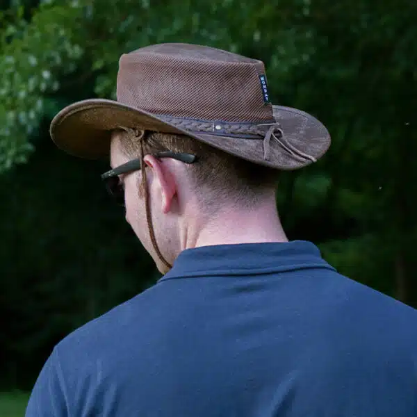 man wearing a wombat the wilds air brown leather hat with mesh sides