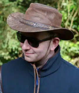 man wearing a wombat the wilds air brown leather hat with mesh sides