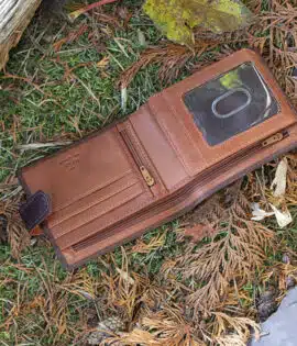 brown leather wallet on a grass and leaf background