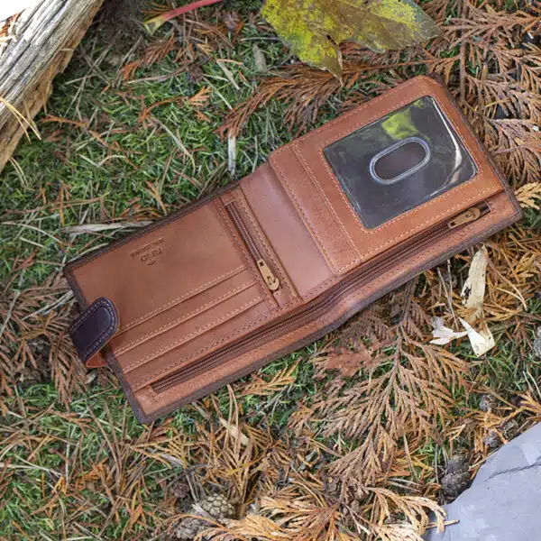 brown leather wallet on a grass and leaf background