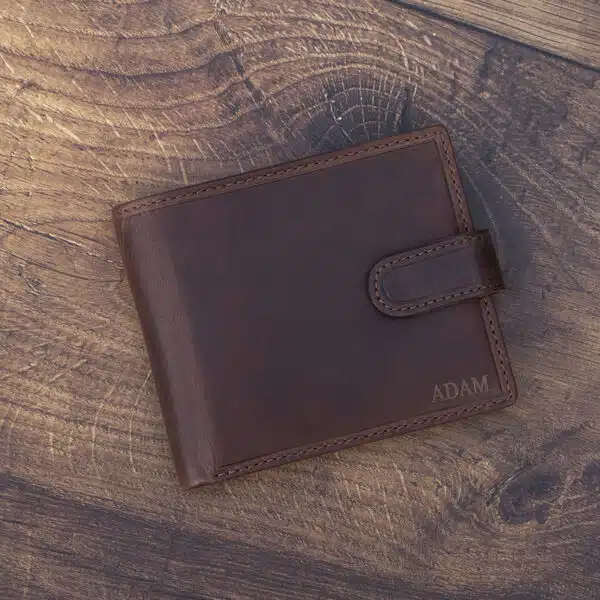 brown leather wallet on a wood background with laser embossing