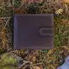 brown leather wallet on a grass and leaf background