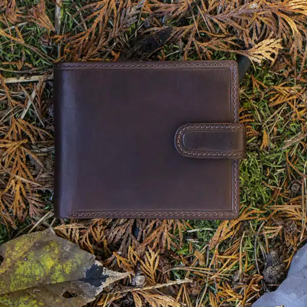 brown leather wallet on a grass and leaf background