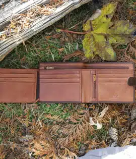 brown leather wallet on a grass and leaf background