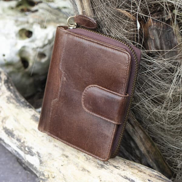 Womans brown vintage style leather bifold purse Wallet with a tab opening side view showing metal zip purse section