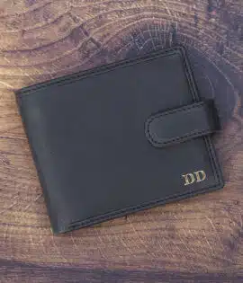 black leather wallet on a wood background with gold foil embossing