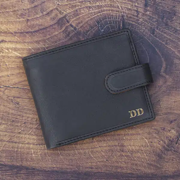 black leather wallet on a wood background with gold foil embossing