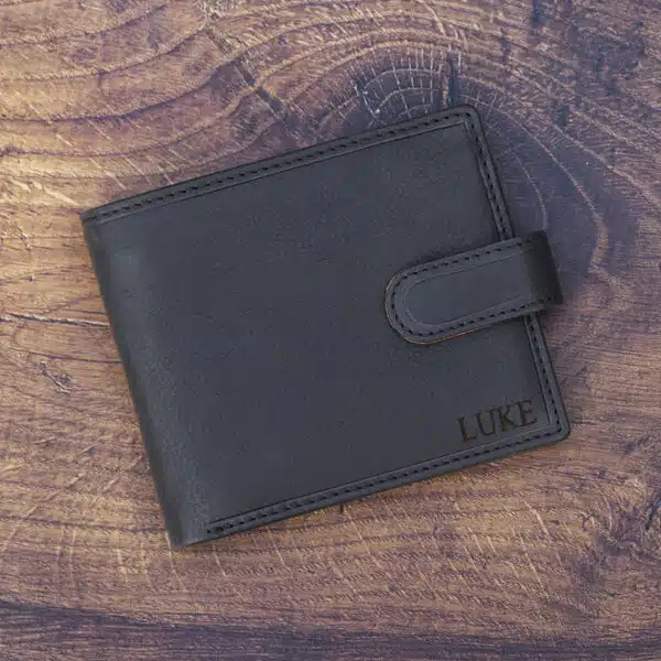 black leather wallet on a wood background with laser embossing