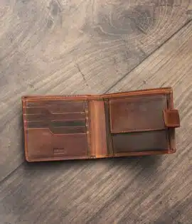 mens tan bifold wallet on a wood background open