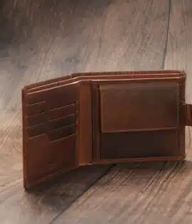 mens tan bifold wallet on a wood background open