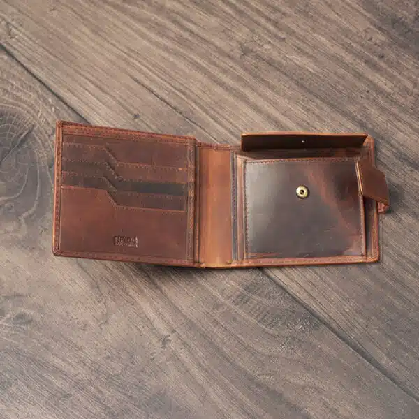 mens tan bifold wallet on a wood background open showing popper change pocket