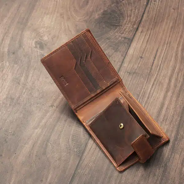 mens tan bifold wallet on a wood background open showing popper change pocket