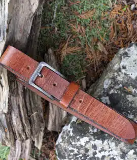 tan leather belt on wood and stone background