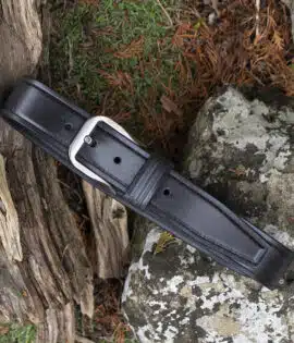 black leather belt on wood and stone background