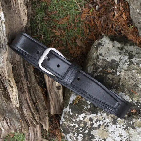 black leather belt on wood and stone background