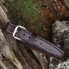 brown leather belt on wood and stone background