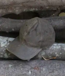 wombat soft distressed leather outdoor cap on a wooden log