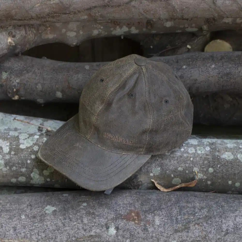 wombat soft distressed leather outdoor cap on a wooden log
