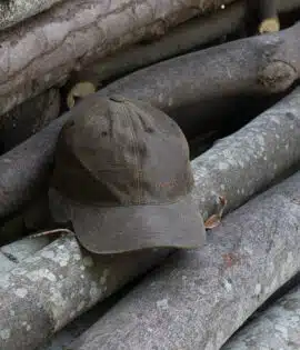 wombat soft distressed leather outdoor cap on a wooden log