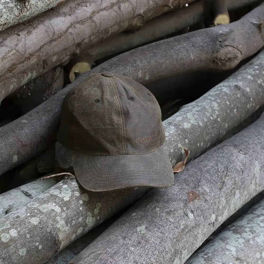 wombat soft distressed leather outdoor cap on a wooden log