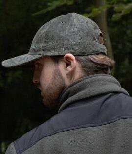 man wearing a green leather cap by wombat side view