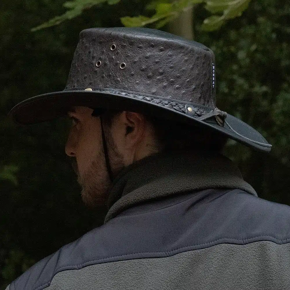 man wearing a black leather hat side on view