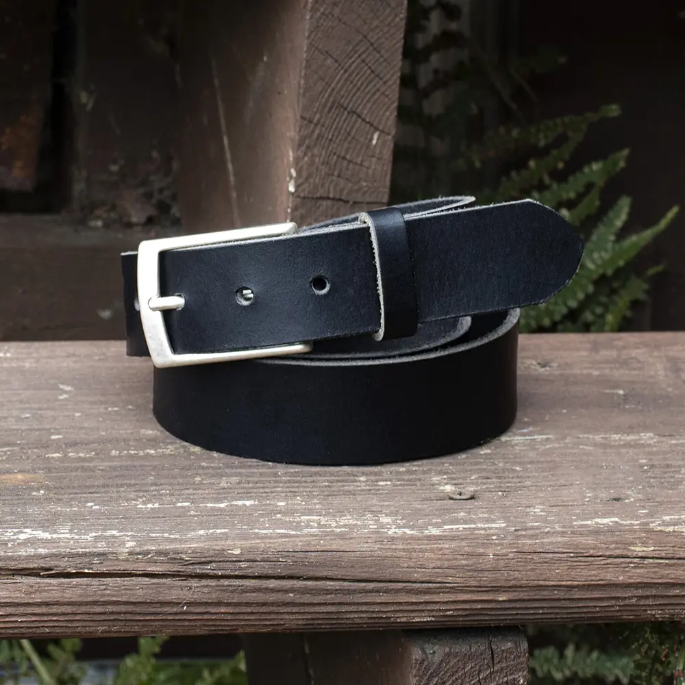 Black 35mm leather belt coiled on a wooden step